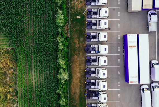 Image of farm field adjacent to a parking lot with trucks