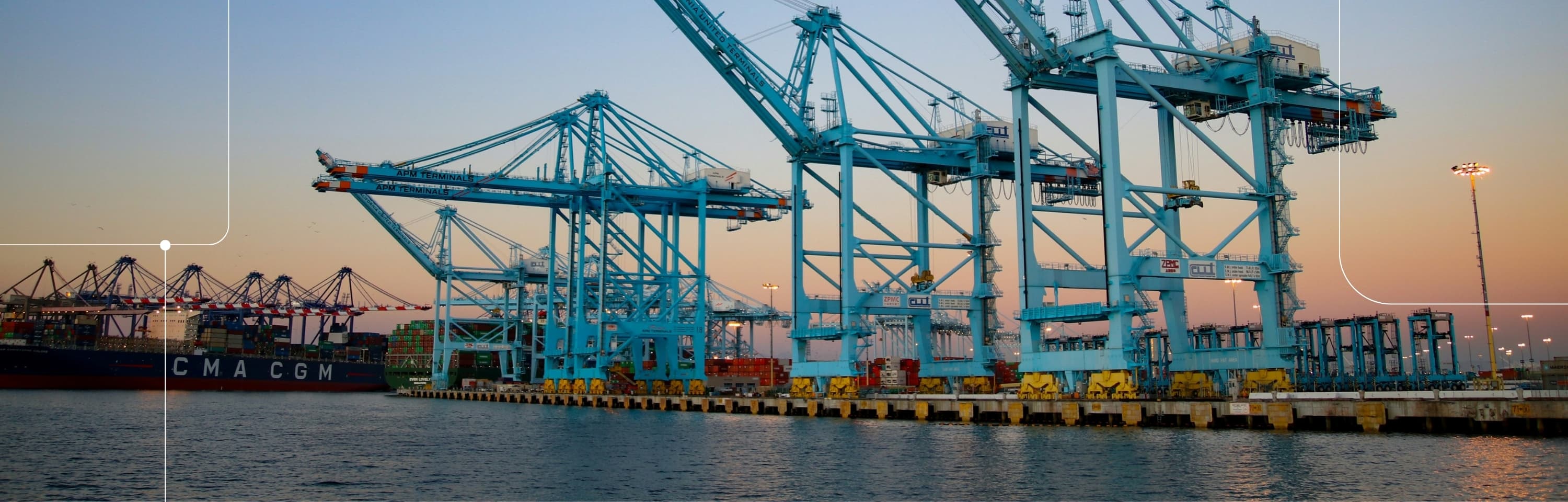 Cargo cranes at a shipping port at dusk